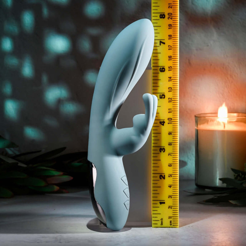 EVOLVED BOSS BUNNY Silicone Rabbit Vibrator with dual motors next to a ruler and candle for size comparison