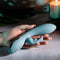 Hand holding the EVOLVED BOSS BUNNY Silicone Rabbit Vibrator with a candle lit background.