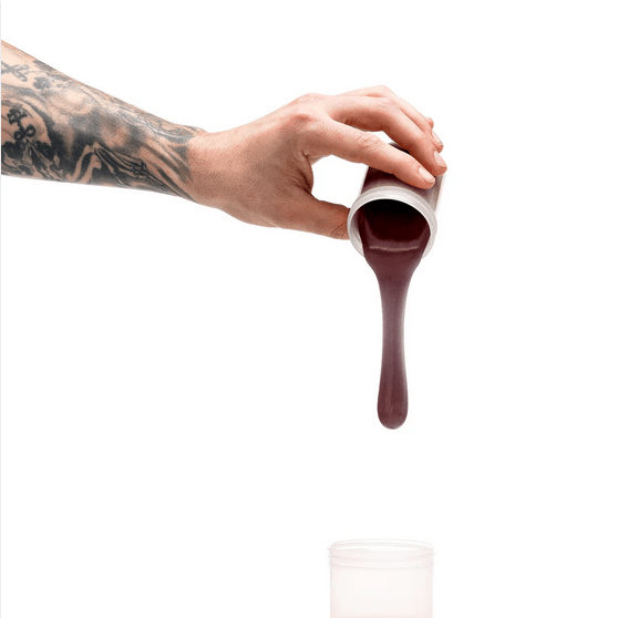 Hand pouring deep skin tone silicone refill for homemade dildo molding into container