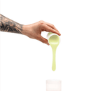Hand pouring glow in the dark green silicone refill into container for homemade dildo casting kit.