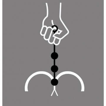 Hand holding Boneyard Ass Ballz Silicone Anal Beads XLarge Black with connected spheres on a gray background.