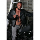 Model holding Boneyard Ass Ballz Silicone Anal Beads XLarge Black while posing with motorcycle in leather jacket.