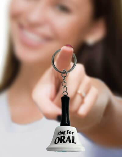 Woman holding novelty "Ring for Oral" keychain from Little Genie's Super Fun Key Chain collection, adding humor to any keyring.