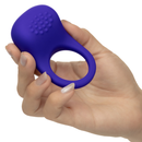 Rumbler Rumble Silicone Vibrating Cock Ring Purple held in a hand, showcasing its textured surface for enhanced pleasure.