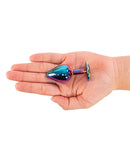 Camtoyz Solari Anal Plug Rainbow in hand, showcasing its polished stainless steel and iridescent finish.