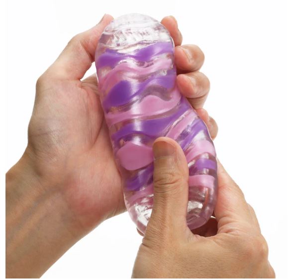 Tenga Arte Drape Stroker held in hand, showcasing its textured design and colors for a unique pleasure experience.