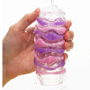 Tenga Arte Drape Stroker held in hand with water flowing over its textured surface.
