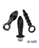 Dr Tushs Dark Curiosity Collection Anal Plug Set Glass showcasing three unique borosilicate glass plugs.