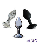 Dr Tush's First Step Anal Plug Set Glass Metal Silicone featuring three distinct plugs in glass, metal, and silicone.