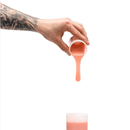 Pouring Clone-A-Willy silicone refill in light skin tone into container for creative dildo crafting.
