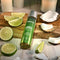 Anoint Perfumery Lime Infused Coconut Massage Oil on wooden board with lime and coconut slices.