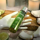 Anoint Perfumery Lime Infused Coconut Massage Oil 4oz in a decorative setting with fresh lime and coconut.