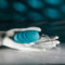 Teal Evolved Oval Office remote control vibrating egg displayed on a white mannequin hand against a dark, moody backdrop
