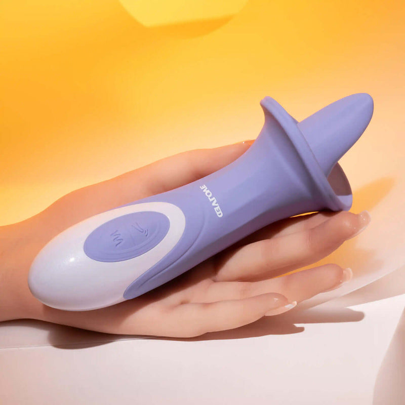 Purple Evolved Lix & Kisses Twirling Tongue Vibrator with 8 speeds held in hand against a soft yellow background