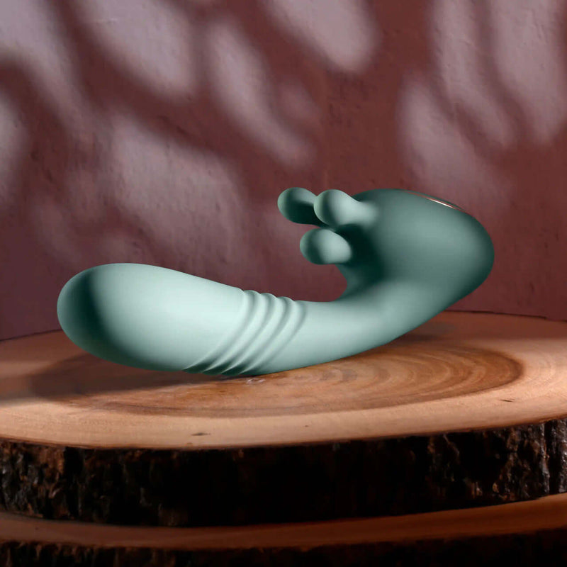 Poseable thrusting vibrator with rotating prongs on wooden surface for intense pleasure and precise stimulation.