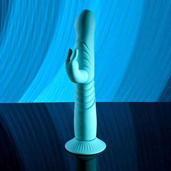 Blue rechargeable silicone throbbing rabbit vibrator with suction base against a blue background.