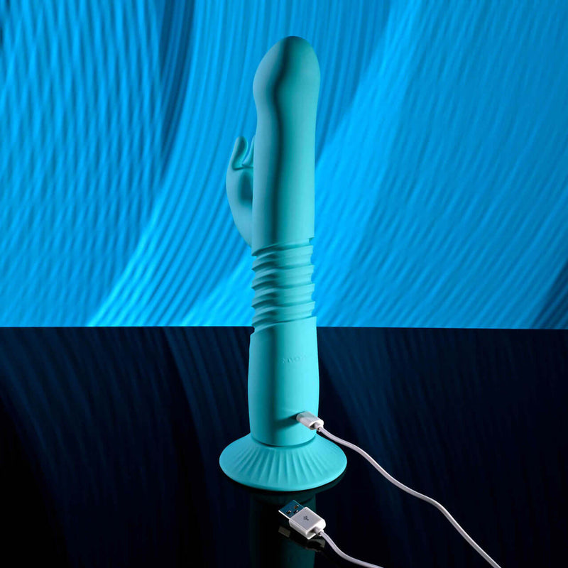Bunny Hop Rechargeable Silicone Throbbing Rabbit Vibrator in blue with USB charger and suction cup base.