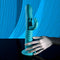 Blue rechargeable silicone rabbit vibrator with thrusting feature and suction cup base on a reflective surface.