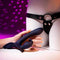Giving Vibes rechargeable silicone triple vibrator in hand, designed for intense pleasure with adjustable harness.