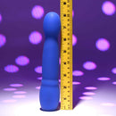 Disco Diva Rechargeable Silicone Vibrator Blue next to a ruler showing its size against a colorful background.