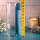 Queen of All Trades rechargeable silicone dual vibrator in blue next to a measuring tool for size comparison.