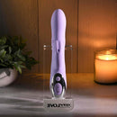 Spinderella Rechargeable Silicone Rabbit Vibrator Purple displayed in a sleek stand with calming candlelight.