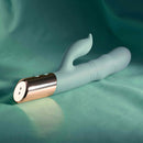 The Shimmy Vibrator with Clitoral Stimulator Green on a soft teal background, showcasing its sleek design and functionalities.