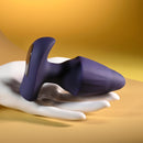 Starburst Expandable Anal Plug with Remote Purple displayed on a hand against a vibrant background.