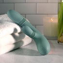 Evolved Rub Me Tender G-spot Clitoral Stimulator surrounded by towels and a candle, showcasing its ergonomic design.
