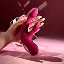 Gentle Persuasion Vibrator with Clitoral Stimulator Red held in hand against a stylish background.