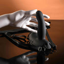 Come Closer Strap-On Vibrator with Remote Black showcased with a hand, highlighting its design and harness features.