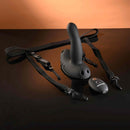 Come Closer Strap-On Vibrator with Remote Black on a table with harness and remote control.
