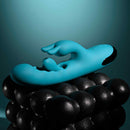 Bunny Tapper Tapping Rabbit Vibrator Blue resting on black textured surface with soft glow background.