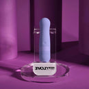Squishy Bullet Rechargeable Silicone Vibrator Purple displayed on a clear stand against a purple background.
