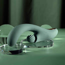 Spiral Charm Rechargeable Clitoral Stimulator Green displayed on a reflective surface with unique design features.