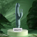 Satin Swirl Rabbit Vibrator with Clitoral Stimulator Green on a display pedestal surrounded by green foliage.