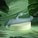 Satin Swirl Rabbit Vibrator with Clitoral Stimulator Green on a light green pedestal surrounded by tropical leaves.