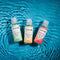 Gender X Flavored Lube Travel 3-Pack featuring Spa Bit, Tropical Fusion, and Peach Bliss on a water background.