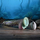 Gender X Monsters Ball Thrusting Vibrating Dildo with Remote Control on a wooden surface with an ocean background.