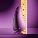 Gender X BJ Buddy Hand Vibrator Purple next to a ruler for size comparison on a reflective surface.