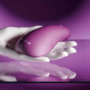Gender X BJ Buddy Hand Vibrator Purple resting in a smooth, cupped hand for enhanced comfort and control.