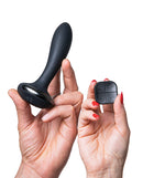 Hot Octopuss PleX with Flex Vibrating Butt Plug Black held in hands alongside remote control.