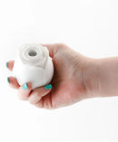 Inya The Rose Glow in the Dark Clitoral Stimulator held in a hand, showcasing its elegant rose design.