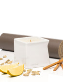 Jimmyjane Natural Massage Oil Candle 4.5 Oz Santal on a white surface with lemon and spice.