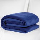 Liberator Fascinator Moisture Barrier Throw Indigo folded on a white bed, showcasing its plush microfiber texture.