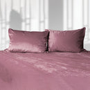 Liberator Fascinator Liquid Velvet Fitted Sheet King Rose on bed with plush pink pillows.