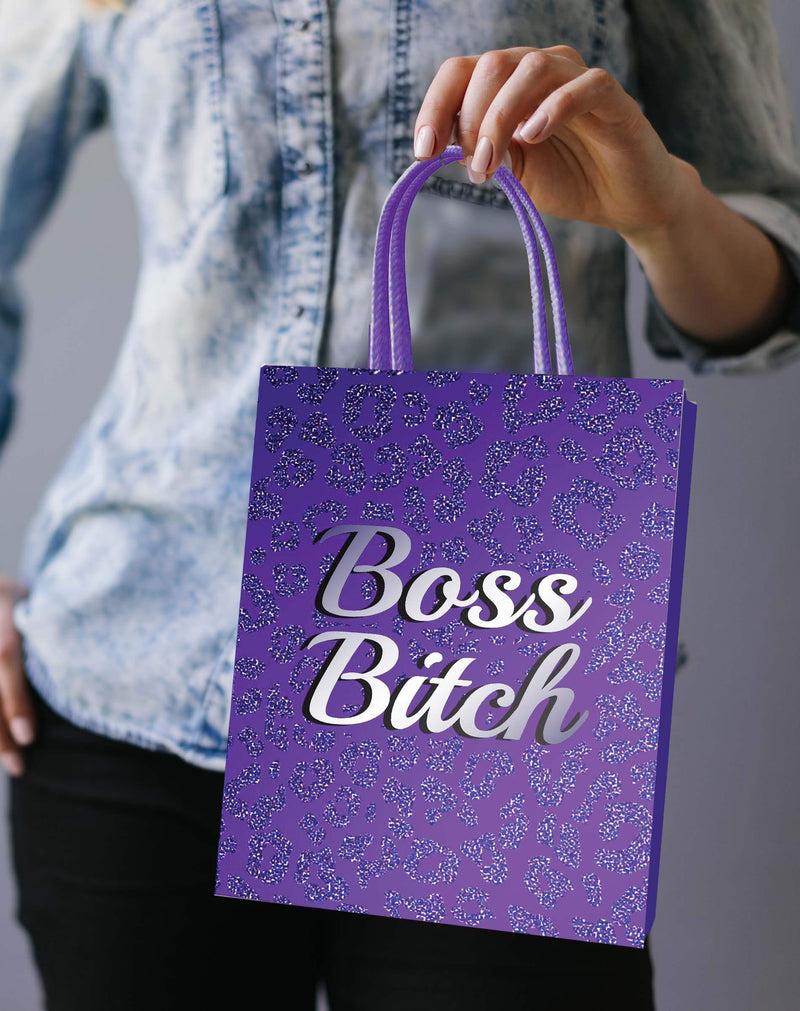 Person holding a purple Boss Bitch Gift Bag with elegant woven handle, perfect for VIP party gift wrapping.