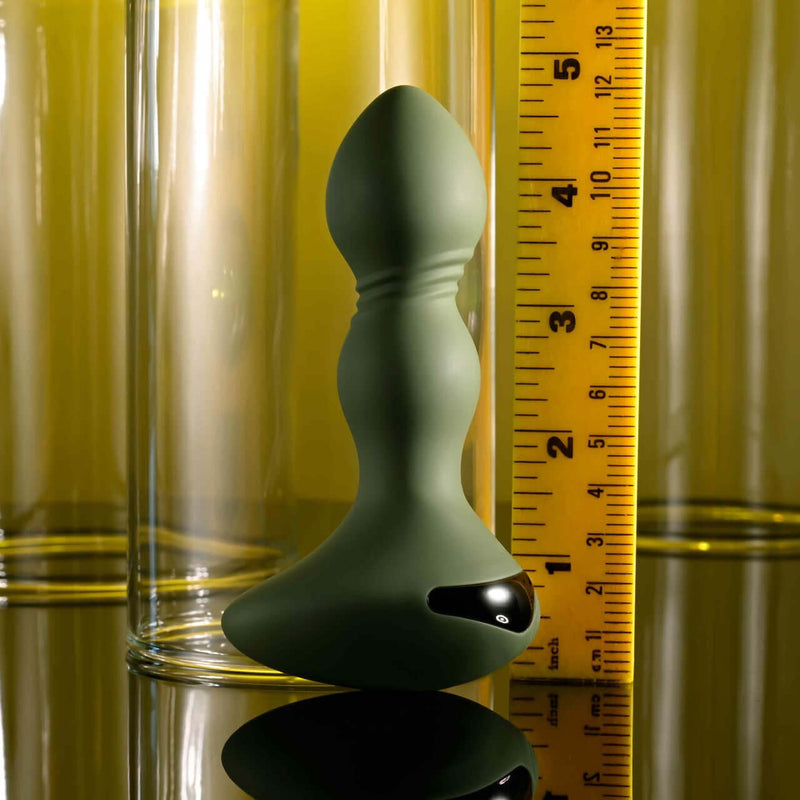 Evolved Lieutenant Vibrating Plug with egg-shaped base and textured shaft next to a ruler for size comparison