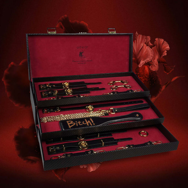 UPKO luxury Italian leather bondage tools set displayed in elegant case with accessories including collars and cuffs.
