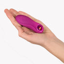 Fun Factory Bijou Bullet Vibrator Magenta held in a hand, showcasing its compact design and wavy texture.